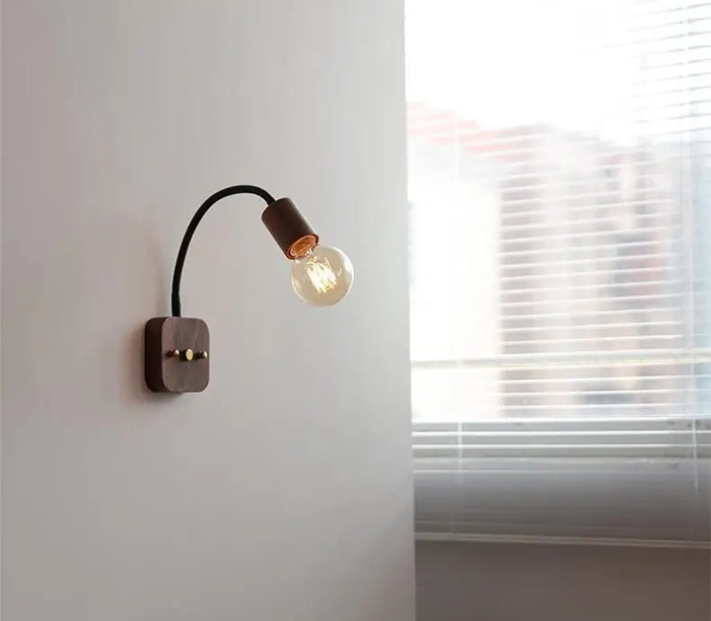 Walnut wood adjustable wall lamp with black arm, minimalist exposed bulb design for modern bedroom or hallway lighting.