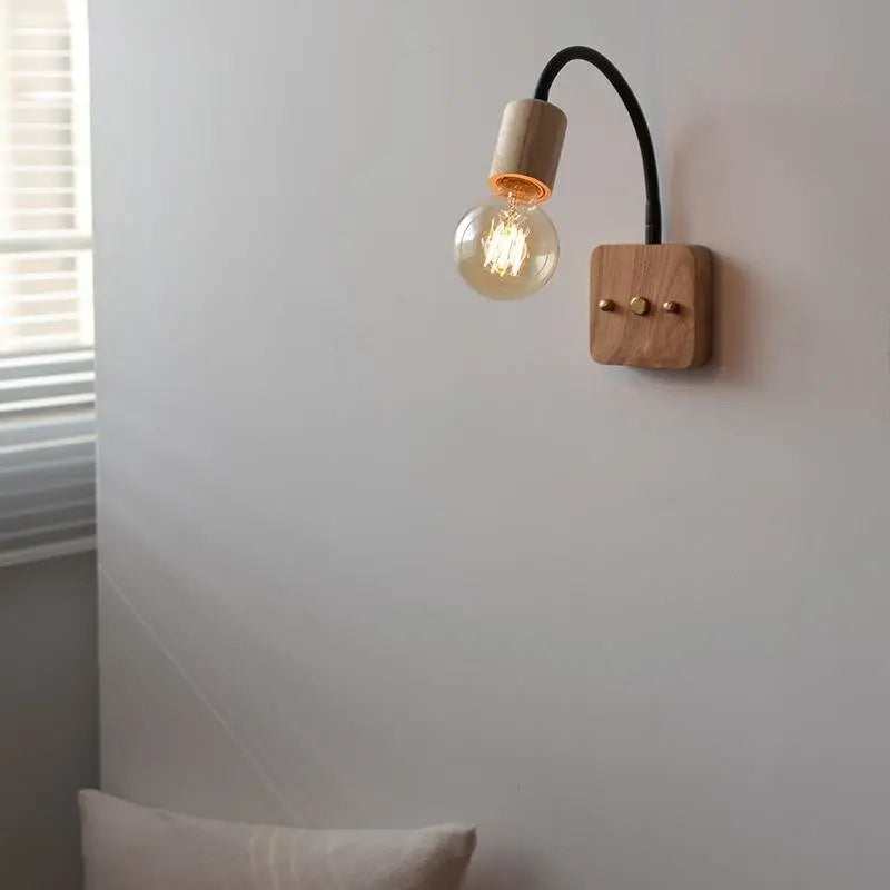 Walnut wood adjustable wall lamp with black arm, minimalist exposed bulb design for modern bedroom or hallway lighting.