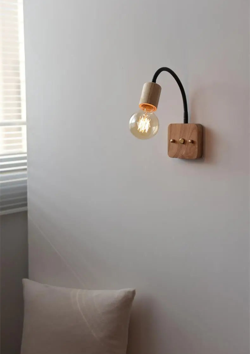 Walnut wood adjustable wall lamp with black arm, minimalist exposed bulb design for modern bedroom or hallway lighting.