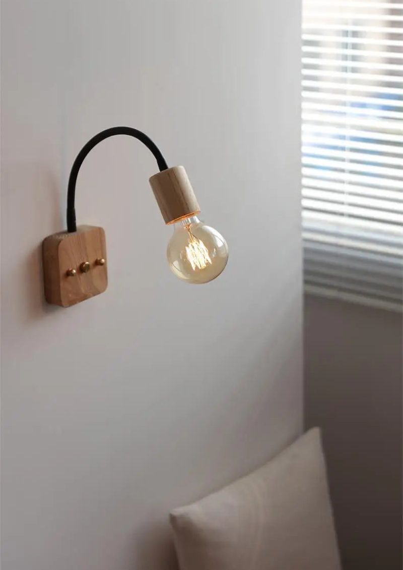 Walnut wood adjustable wall lamp with black arm, minimalist exposed bulb design for modern bedroom or hallway lighting.