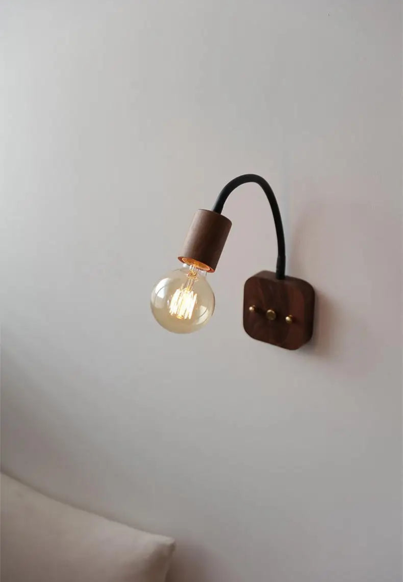 Walnut wood adjustable wall lamp with black arm, minimalist exposed bulb design for modern bedroom or hallway lighting.