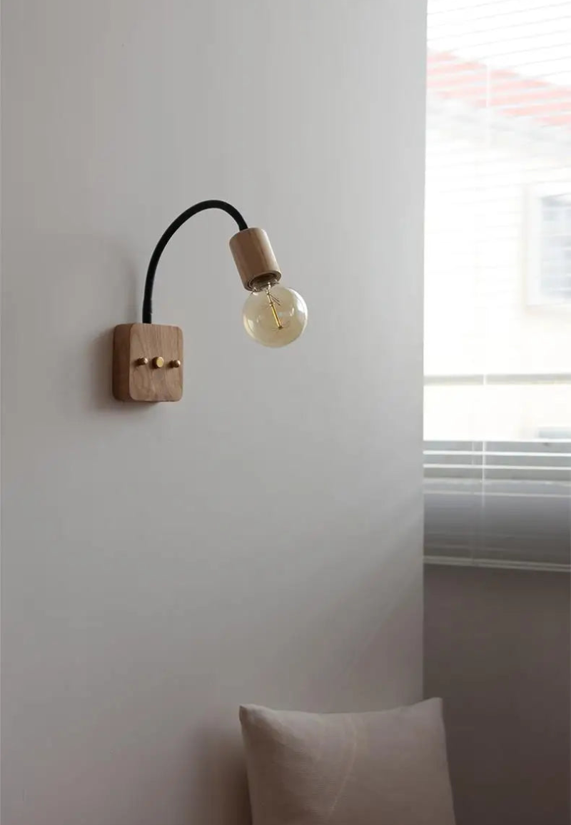 Walnut wood adjustable wall lamp with black arm, minimalist exposed bulb design for modern bedroom or hallway lighting.