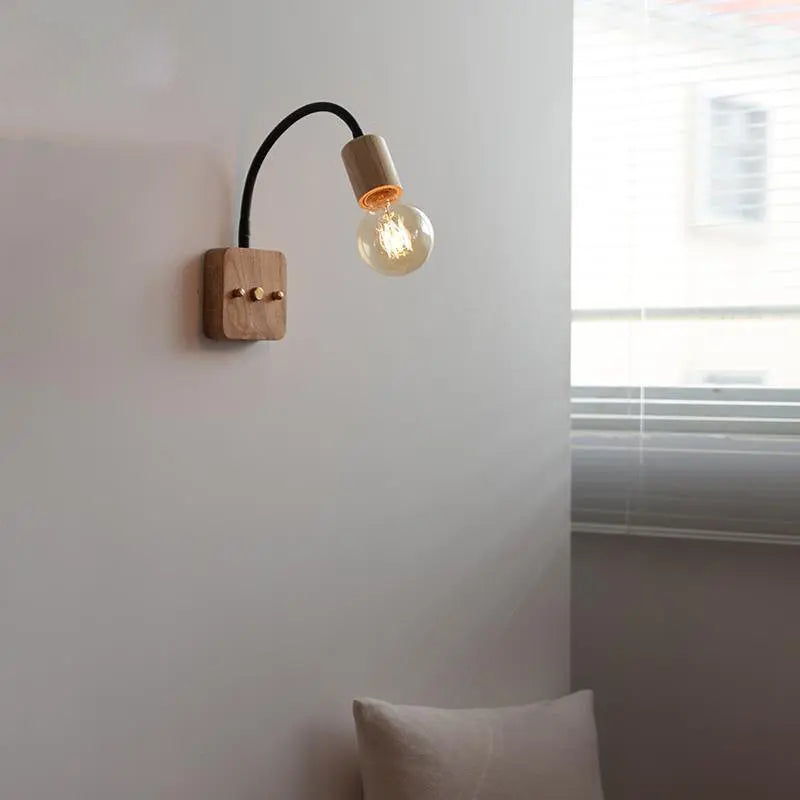 Walnut wood adjustable wall lamp with black arm, minimalist exposed bulb design for modern bedroom or hallway lighting.