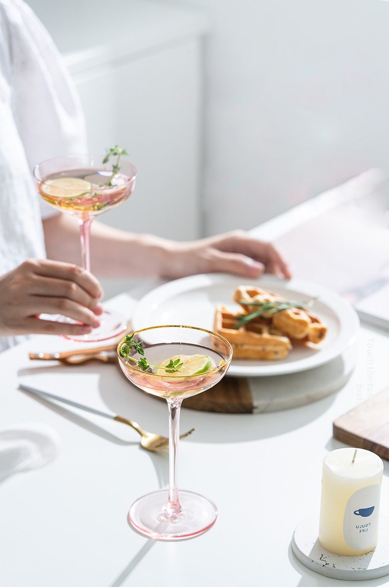 wide round pink champagne glass with gold trimming