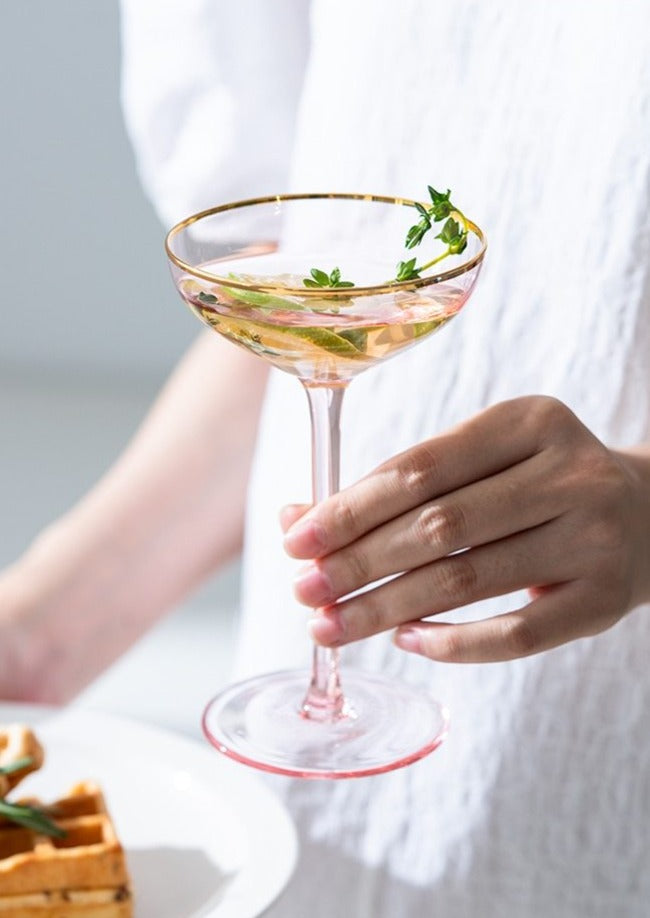 wide round pink champagne glass with gold trimming